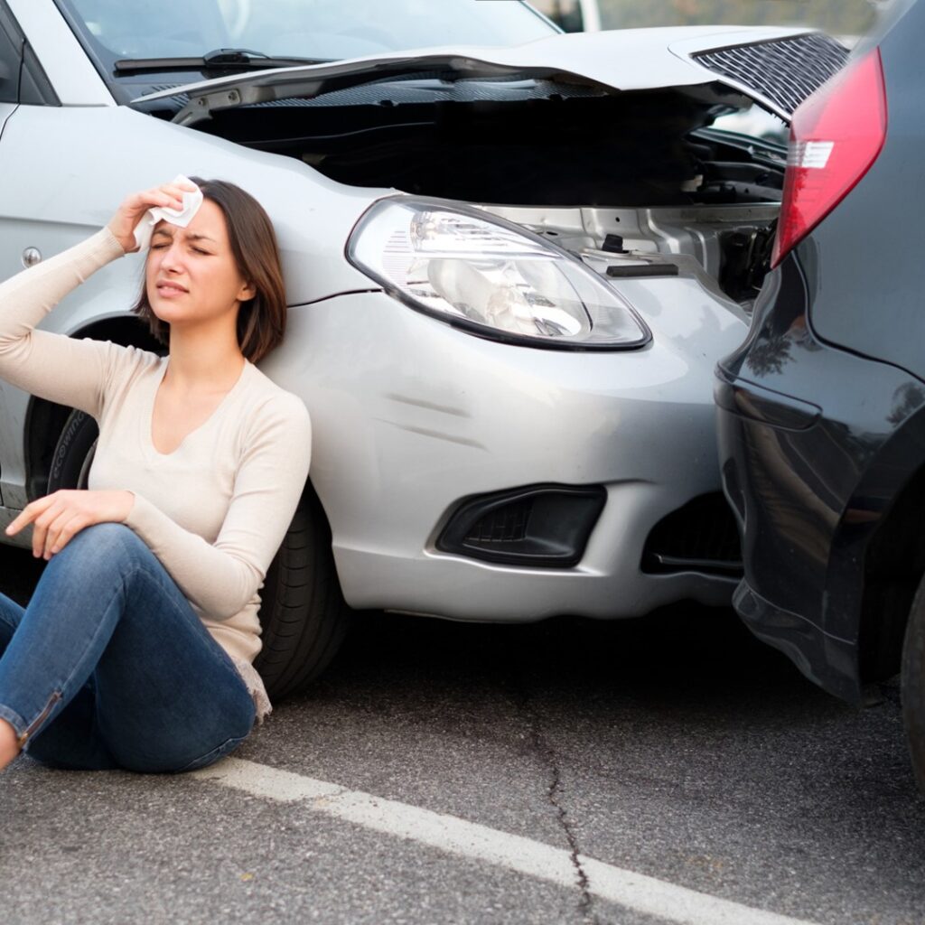 Injured woman near damaged cars after a Southfield accident and personal injury claim.