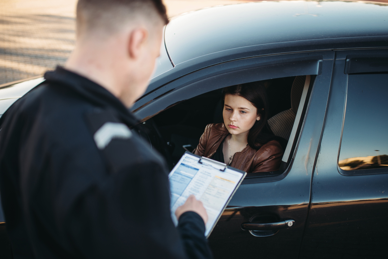 Police officer checking driver's license during traffic stop
